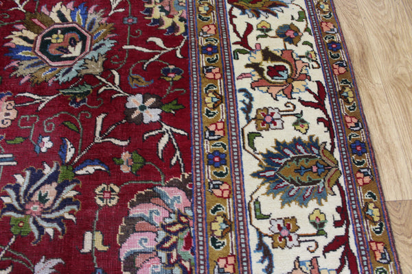 SIGNED PERSIAN TABRIZ CARPET WITH A LARGE SCALE FLORAL DESIGN 325 X 230 CM