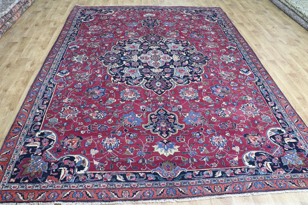 ANTIQUE PERSIAN MASHAD CARPET WITH A LARGE CENTRAL MEDALLION DESIGN 315 X 218 CM
